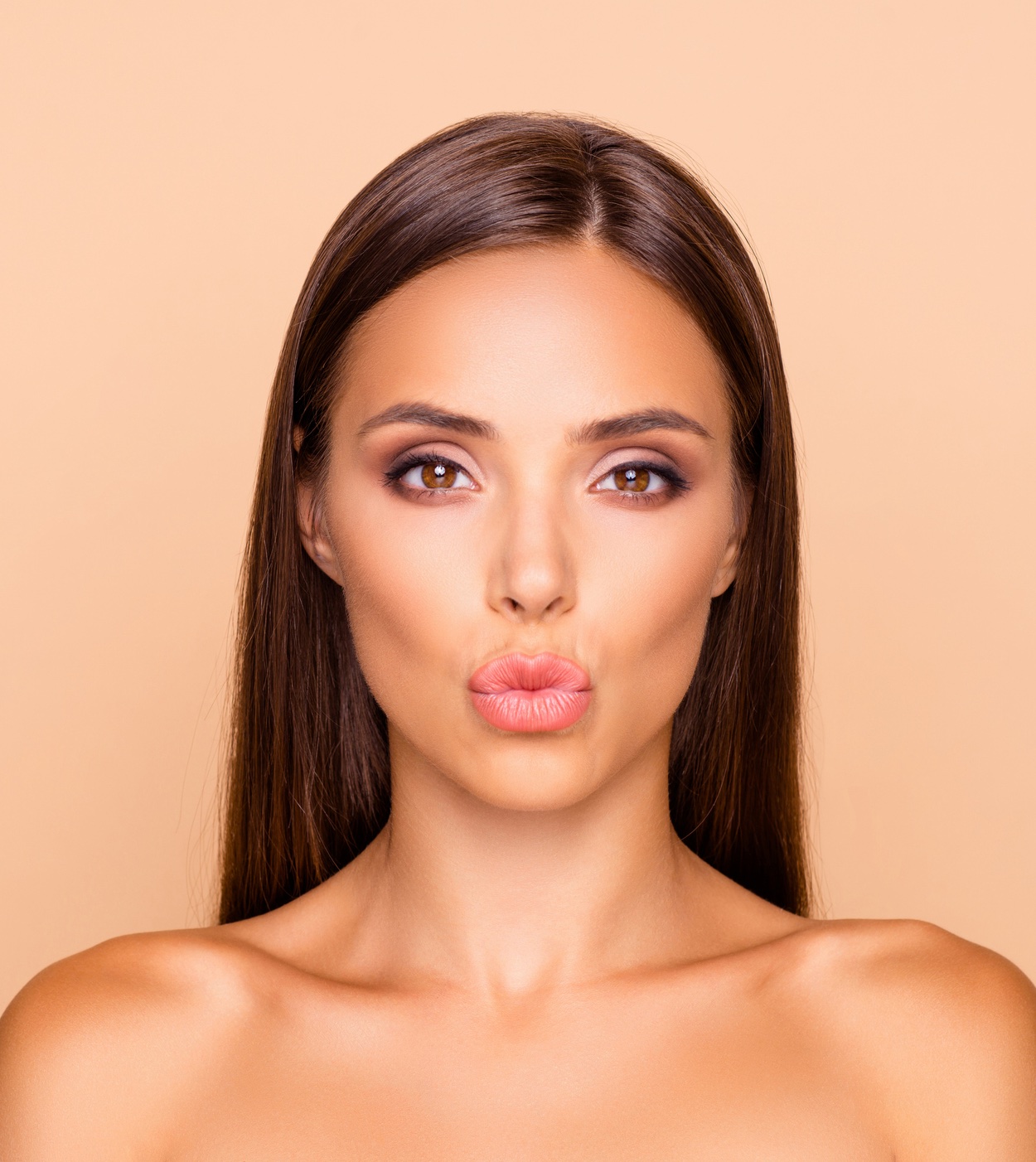 Junge, dunkelhaarige Frau, mit schönen vollen Lippen nach einer Lippenunterspritzung.