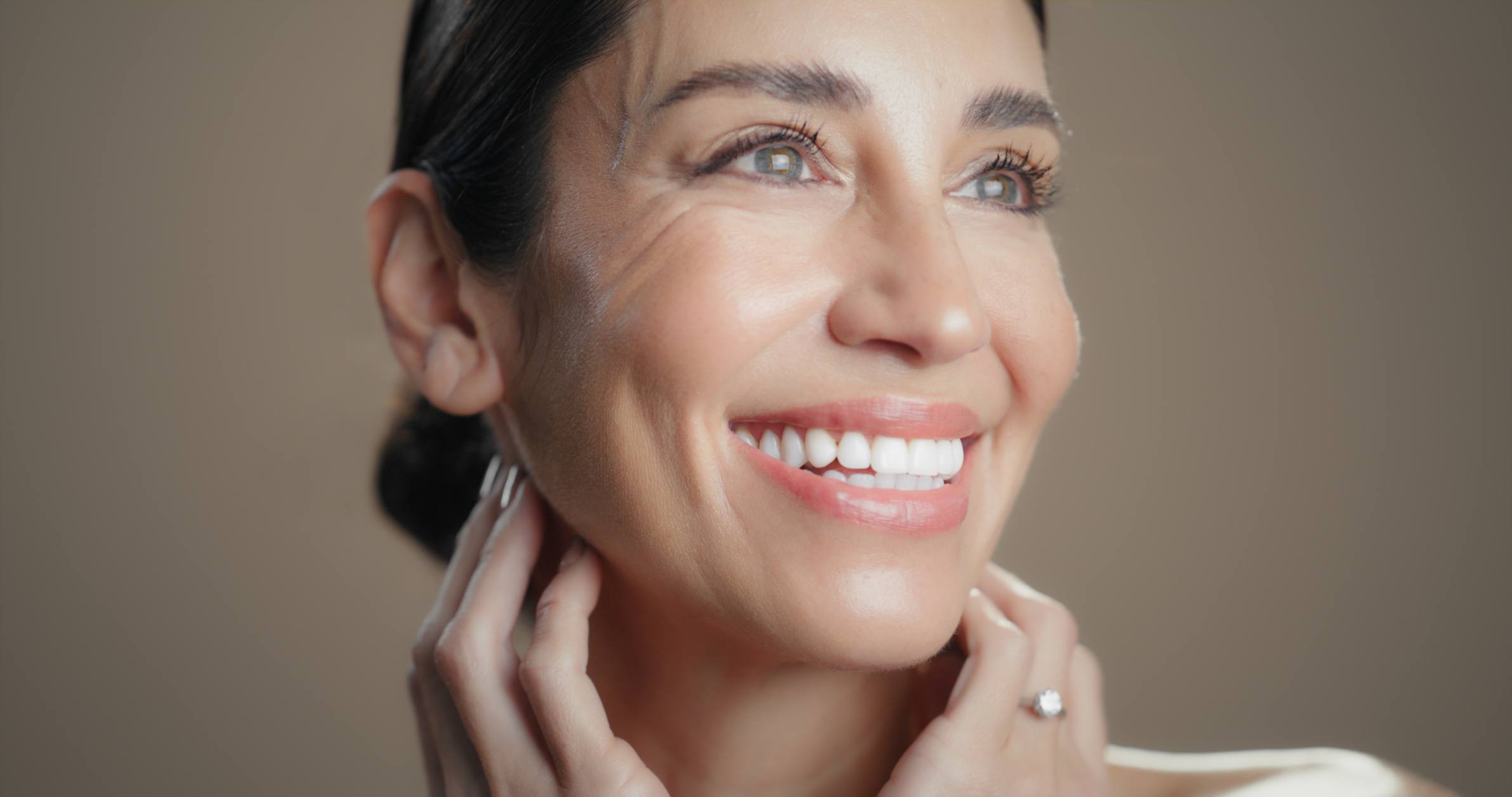 Schöne, lachende Frau, mit frischem Aussehen, nach einer Anti-Aging Gesichtsbehandlung.